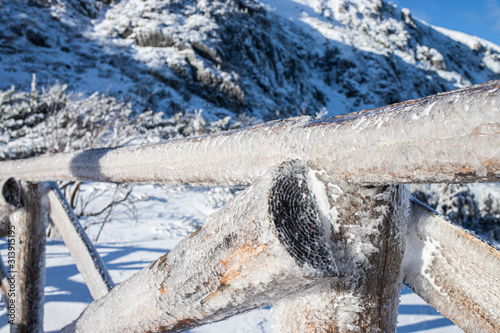 zimowy most drewniany w górach pokryty lodem i śniegiem