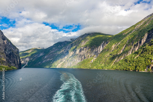 Impression from cruise ship on the way through Geiranger fjord in Norway at sunrise in summer