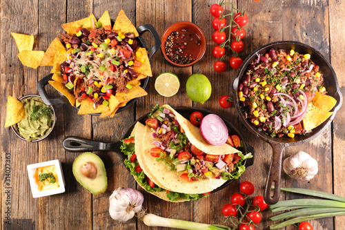 assorted of mexican food with fajitas, chili con carne and nachos with avocado, beef and cheese