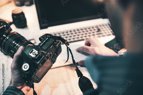 photographer hand camera and computer on desk