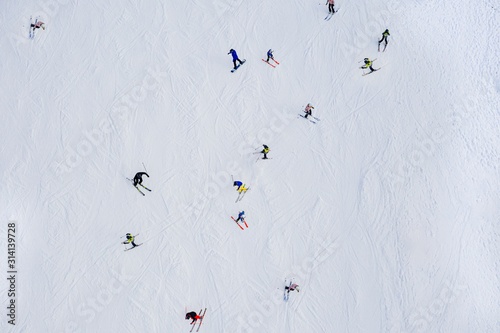 Aerial drone view on skiers on ski slope at winter.