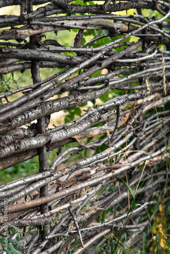 Wooden fence made of interwoven thin tree branches