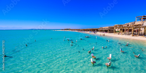 Orange Bay Beach with crystal clear azure water and white beach - paradise coastline of Giftun island, Mahmya, Hurghada, Red Sea, Egypt.