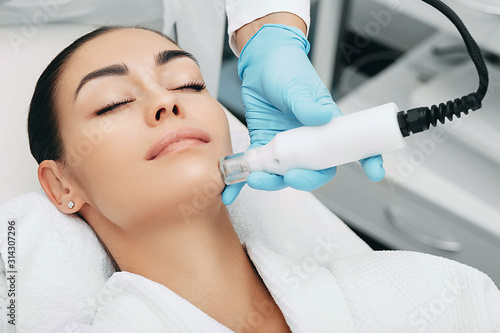 woman receiving no-needle high frequency mesotherapy at beauty salon. non-invasive procedure for skin rejuvenation
