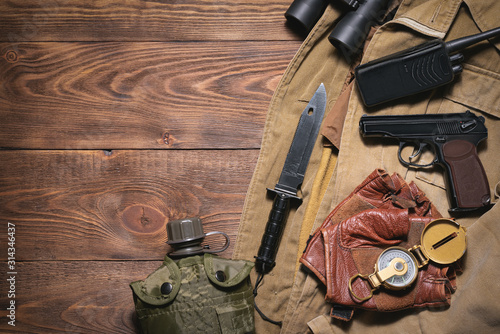 Post apocalypse soldier equipment on the wooden table background concept.