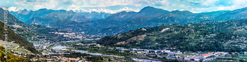 Panoramic view of Var Valley from Saint Laurent du Var village, the suburb of Nice city. Mountains of Mercantour National Park isa at background. French Riviera.