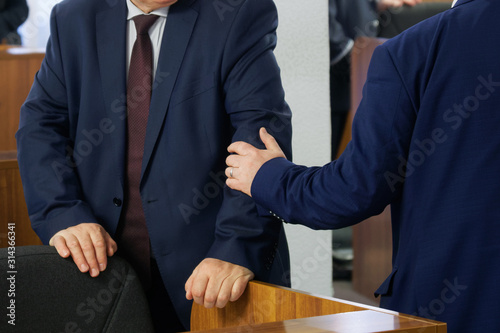 Politicians or businessmen greet each other before the start of a meeting or conference. Preparing for a decision. Head and subordinate. Patronage