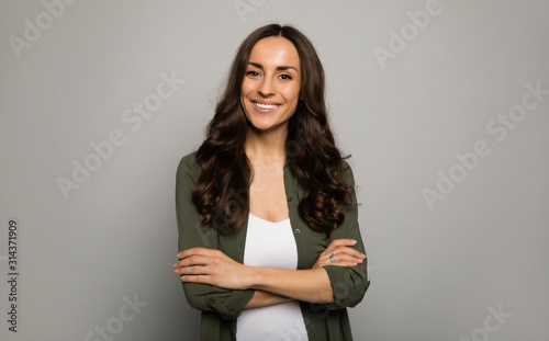 Mrs. Excellence. Close-up photo of adorable woman, posing in white t-shirts and smiling while looking in the camera.