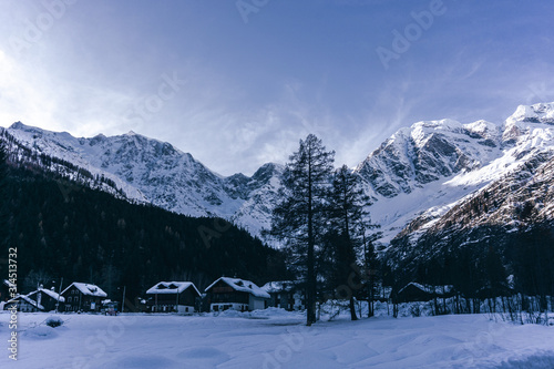 The town of Macugnaga, in the Italian Alps, with its typical houses, the snow and Monte Rosa - December 2019.