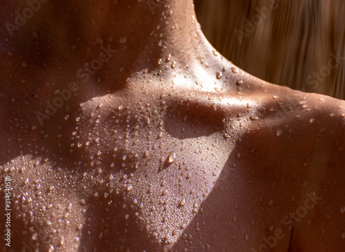 drops of sweat on tanned skin, close-up