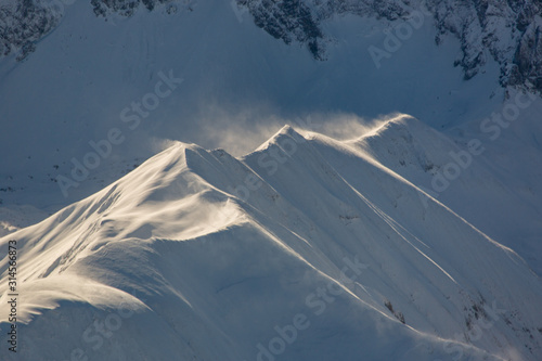 Luftaufnahme Schneeverwehung über hochalpinen Gipfeln