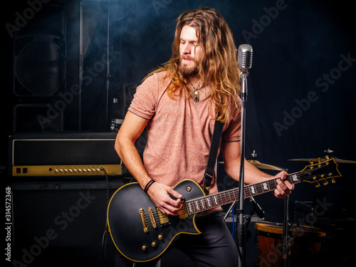 Young man playing electric guitar on stage