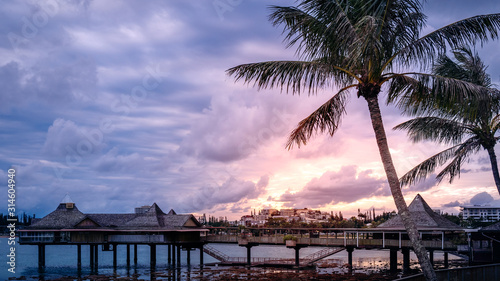 The coast at Anse Vata Bay with the sunset over Noumea cityscape in the background - New Caledonia, French Polynesia, South Pacific. Ocean