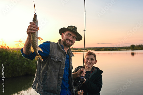 Father and son happy because they caught big pike. This is their first catch.
