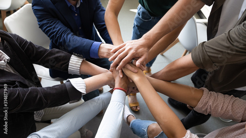 Top view hands stacked together as symbol of teambuilding