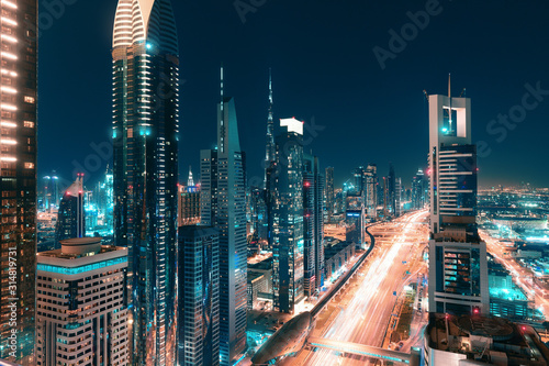 Night view of the spectacular landscape of Dubai with high-rises and skyscrapers at the Sheikh Zayed highway. Global travel destinations and real estate concept