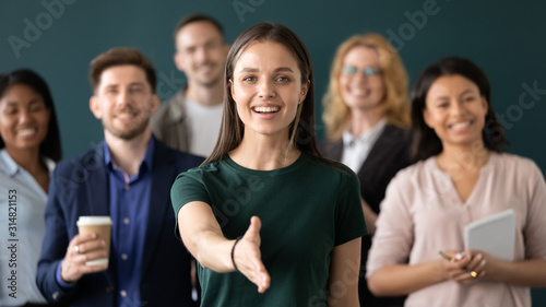 Woman company representative holds out hand for handshake welcoming client