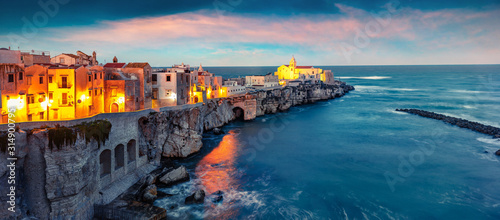 Dramatic evening cityscape of Vieste - coastal town in Gargano National Park, Italy, Europe. Splendid spring sunset on Adriatic sea. Traveling concept background.