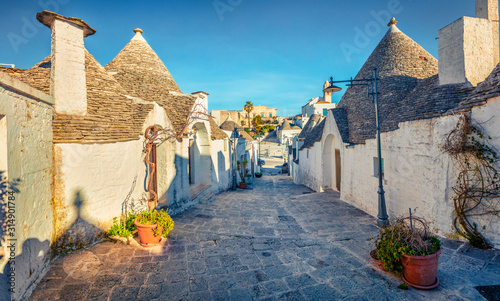 Colorful morning view of strret with trullo - traditional Apulian dry stone hut with a conical roof. Nice spring cityscape of Alberobello town, province of Bari, Apulia region, Italy, Europe.