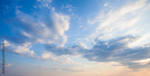 Blue sky clouds background. Beautiful landscape with clouds and orange sun on sky