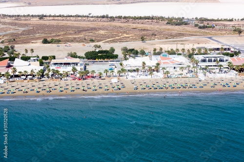 Aerial view at Mackenzie beach with hotel and apartment buildings, sunbeds and umbrellas. It is the beach close to Larnaca International Airport on south of island. Cyprus