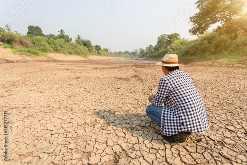 Farmer stand in the dry river and looking to empty water in Sukhothai. For drought season concept.