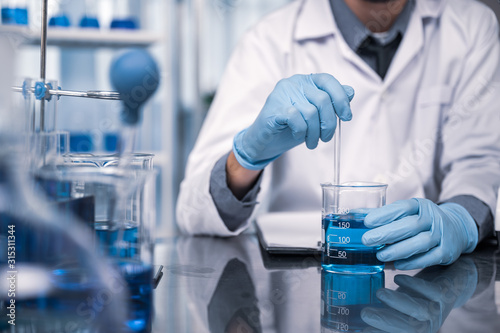 In a Modern Laboratory Research Scientist Conducts Experiments by Synthesising Compounds