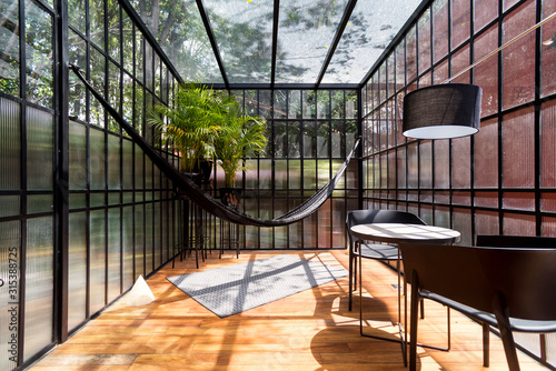 Modern sunroom with a hammock and some plants