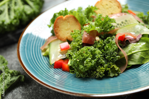Delicious salad with kale leaves on table, closeup