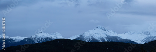 Striking and Dramatic Panoramic Canadian Landscape View of the Mountain Peaks during a cloudy sunset. Taken in Tantalus Lookout near Squamish and Whistler, North of Vancouver, BC, Canada.