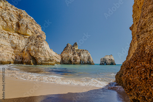 View on typical cliffy beach at Algarve coastline in Portugal in summer