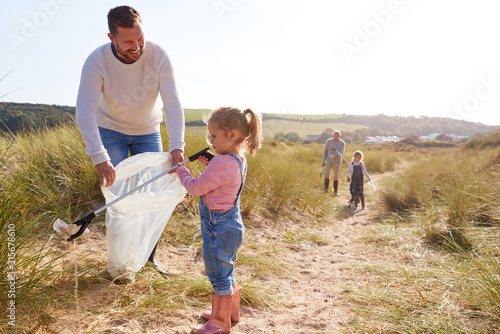 Multi-Generation Family Collecting Litter On Winter Beach Clean Up