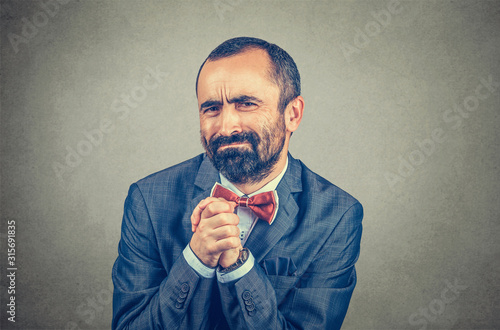 man showing clasped hands, pretty please isolated on gray background. Human emotion facial expression feelings, body language