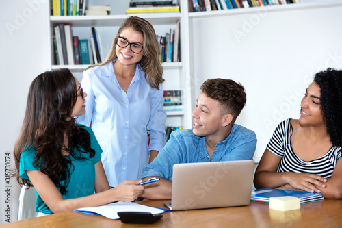 Lehrerin mit jungen Studenten am Computer