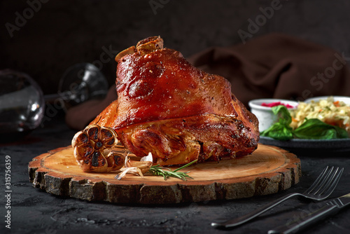 Roasted pork knuckle eisbein with cabbage and mustard on wooden cutting board