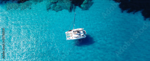 Aerial drone ultra wide photo of sailing yacht anchored in paradise turquoise sea exotic island destination