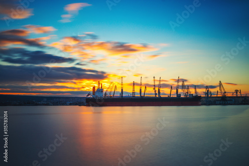 Colorful sunset over sea port and industrial cranes, Varna, Bulgaria.