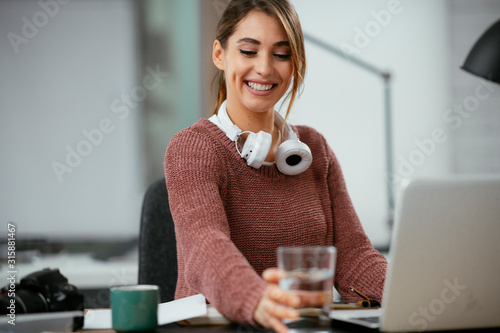 Young businesswoman drinking water in office