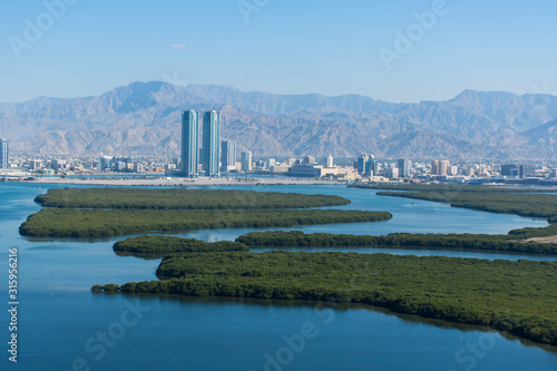 Aerial view of Ras al Khaimah, United Arab Emirates north of Dubai, looking at the city, Hajar mountains - Jebal Jais - and the Mangroves along the Corniche.