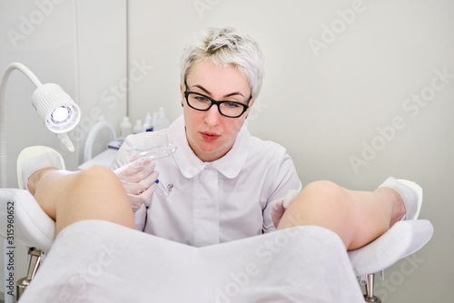 Gynecologist with vaginal speculum in clinic before patient examination