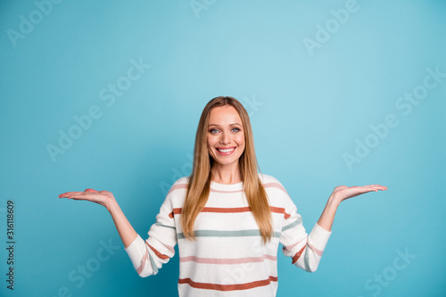 Photo of blonde haired cheerful toothy beaming woman holding two sides of one option for you to estimate isolated empty space pastel color background