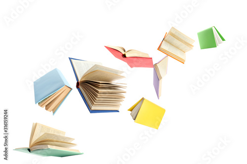 Colorful hardcover books flying on white background