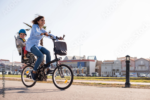 Mother riding on a bicycle with young kid