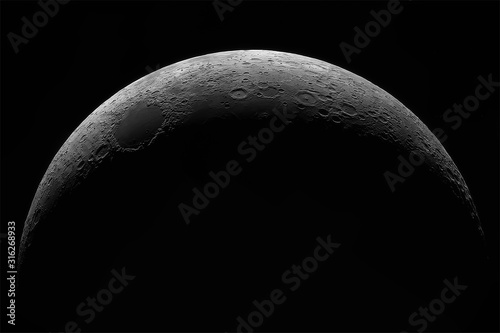 Crescent of a young moon with a large increase. Moon, view through a telescope. The moon with craters. Real photos of space objects through a telescope.