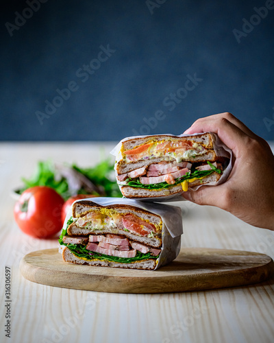Deli sandwich with bacon,eggs,tomato and salad. Delicious food concept.