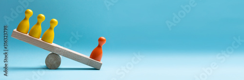 Red And Yellow Pawns Figures Balancing On Wooden Seesaw