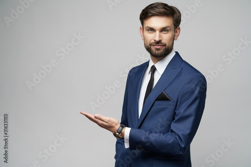 Portrait of a young businessman pointing on a copyspace with his finger