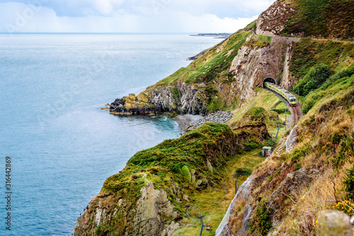Train exiting a tunnel. View from Cliff Walk Bray to Greystones with beautiful coastline, cliffs and sea, Ireland