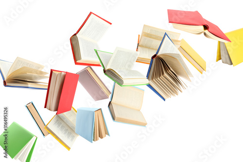 Colorful hardcover books flying on white background