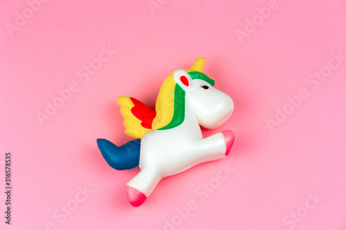 top view squishy unicorn toy on a pastel pink background
